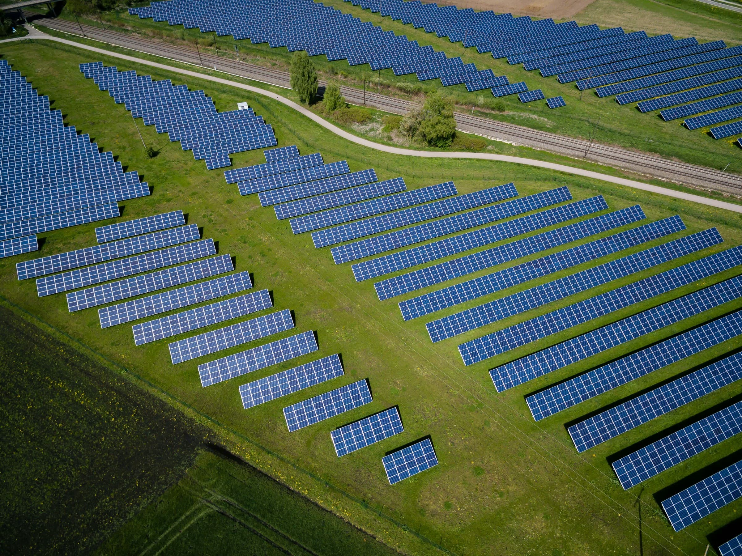 Aerial view of a grass field with blue solar panels